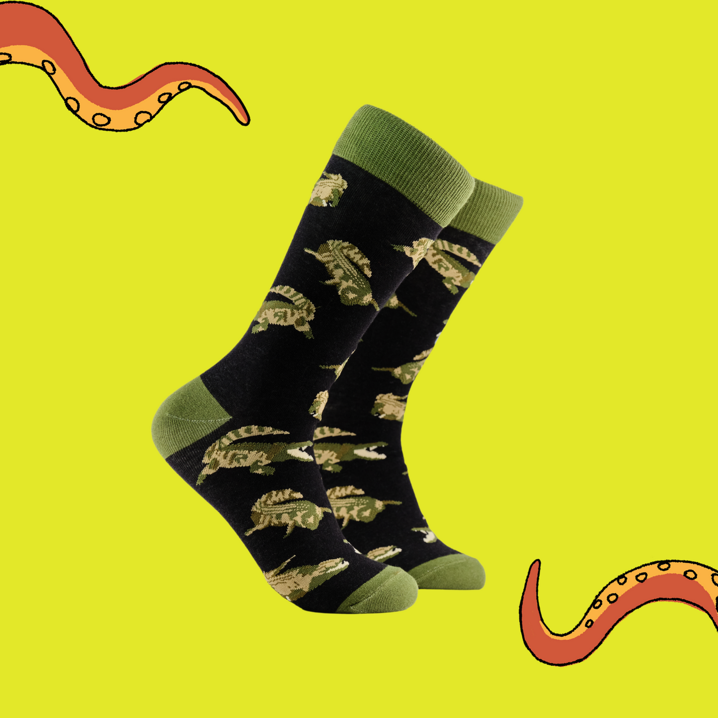 A pair of socks depicting crocodiles. Dark blue legs, green cuff, heel and toe.