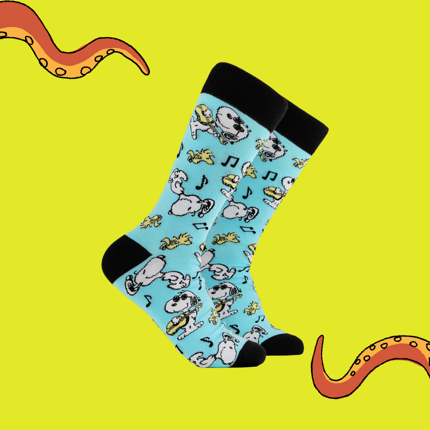 A pair of socks depicting snoopy and woodstock jamming. Turquoise legs, black cuff, heel and toe.