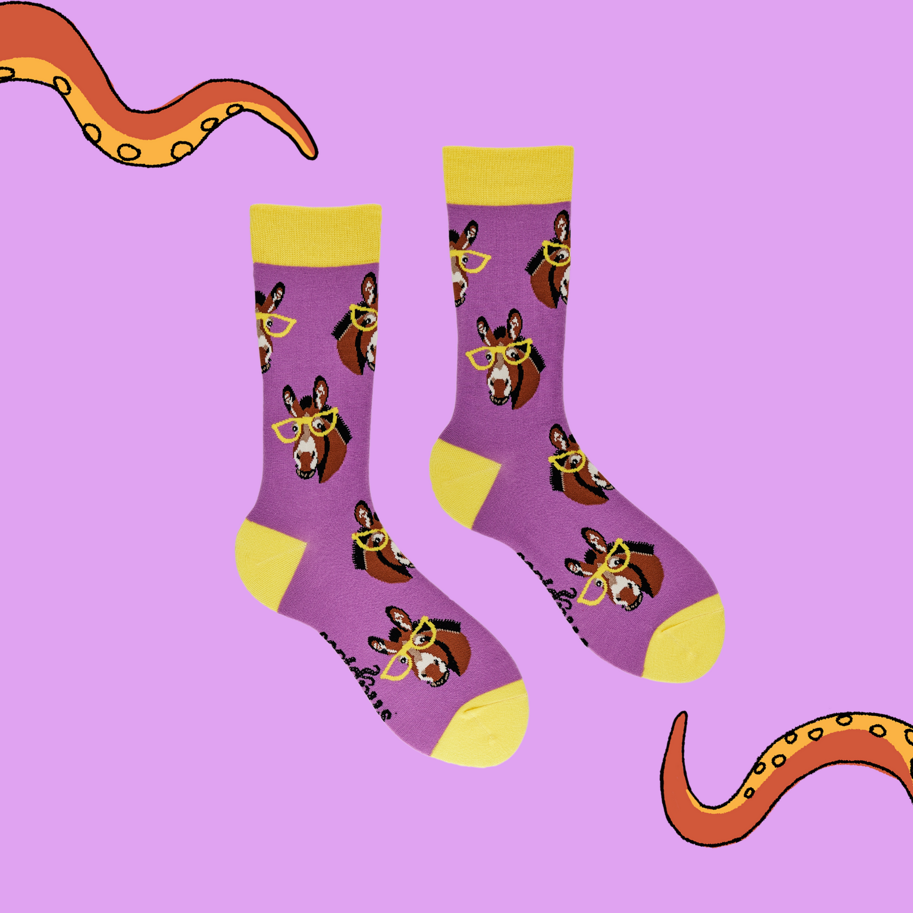 
                  
                    A pair of socks depicting donkeys wearing glasses. Bright pink legs, yellow cuff, heel and toe.
                  
                