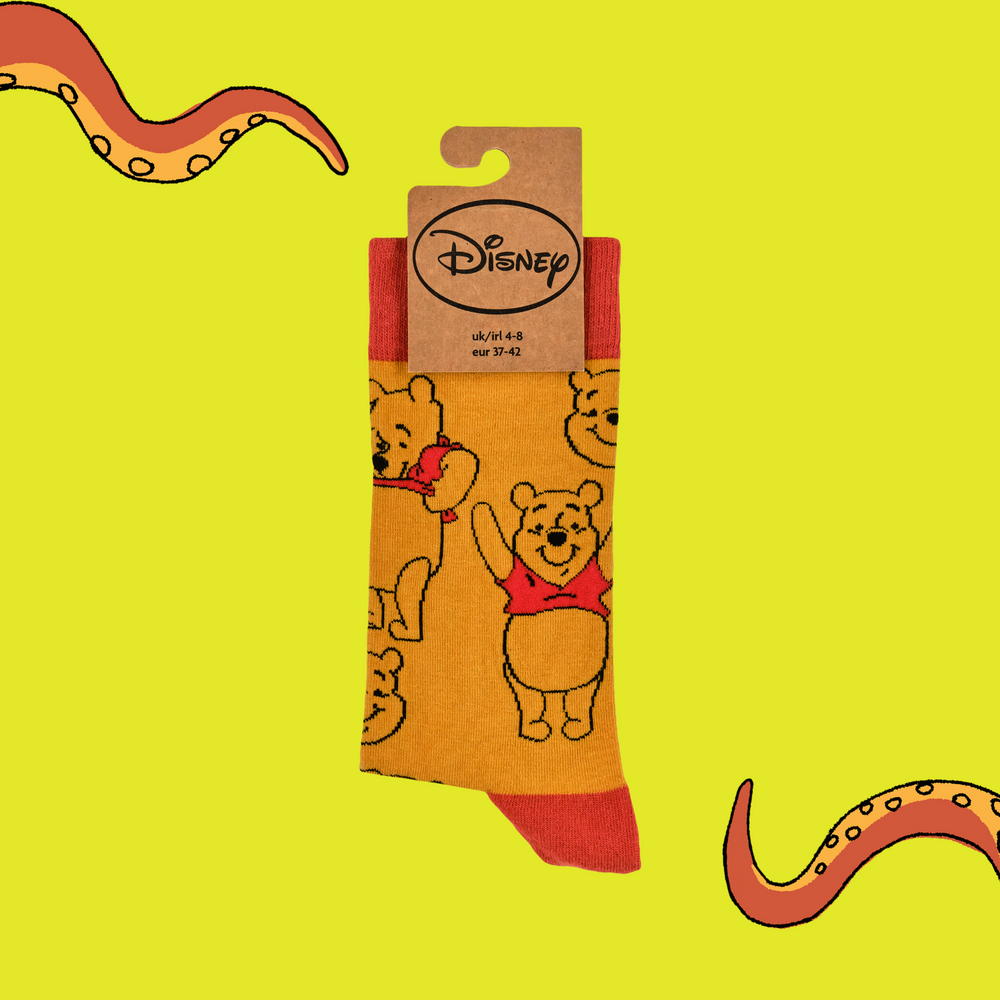 
                      
                        A pair of socks featuring Winne the Pooh. Yellow legs, red toe, cuff and heel. 
                      
                    