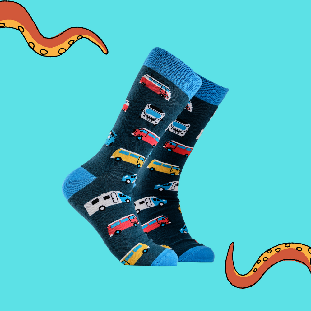 A pair of socks depicting campervans. Dark blue legs, light blue cuff, heel and toe.