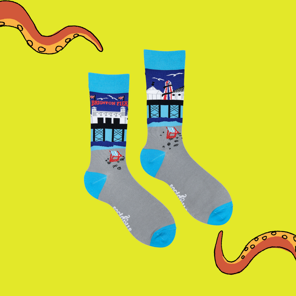 
                      
                         A pair of socks depicting Brighton Pier. Grey legs, light blue cuff, heel and toe.
                      
                    