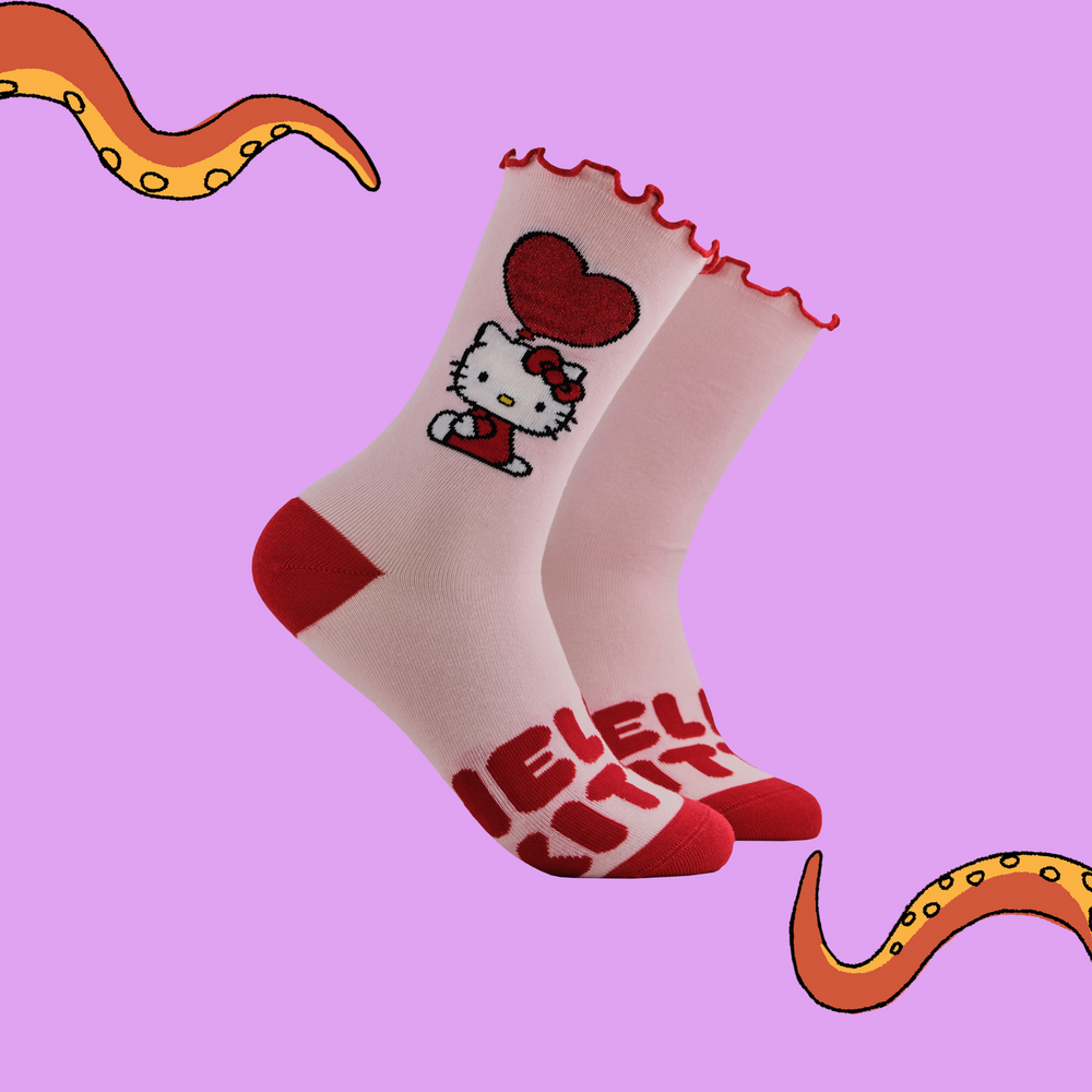 A pair of socks depicting Japanese icon Hello Kitty. Pink legs, read toe and heel with a frilly red cuff.