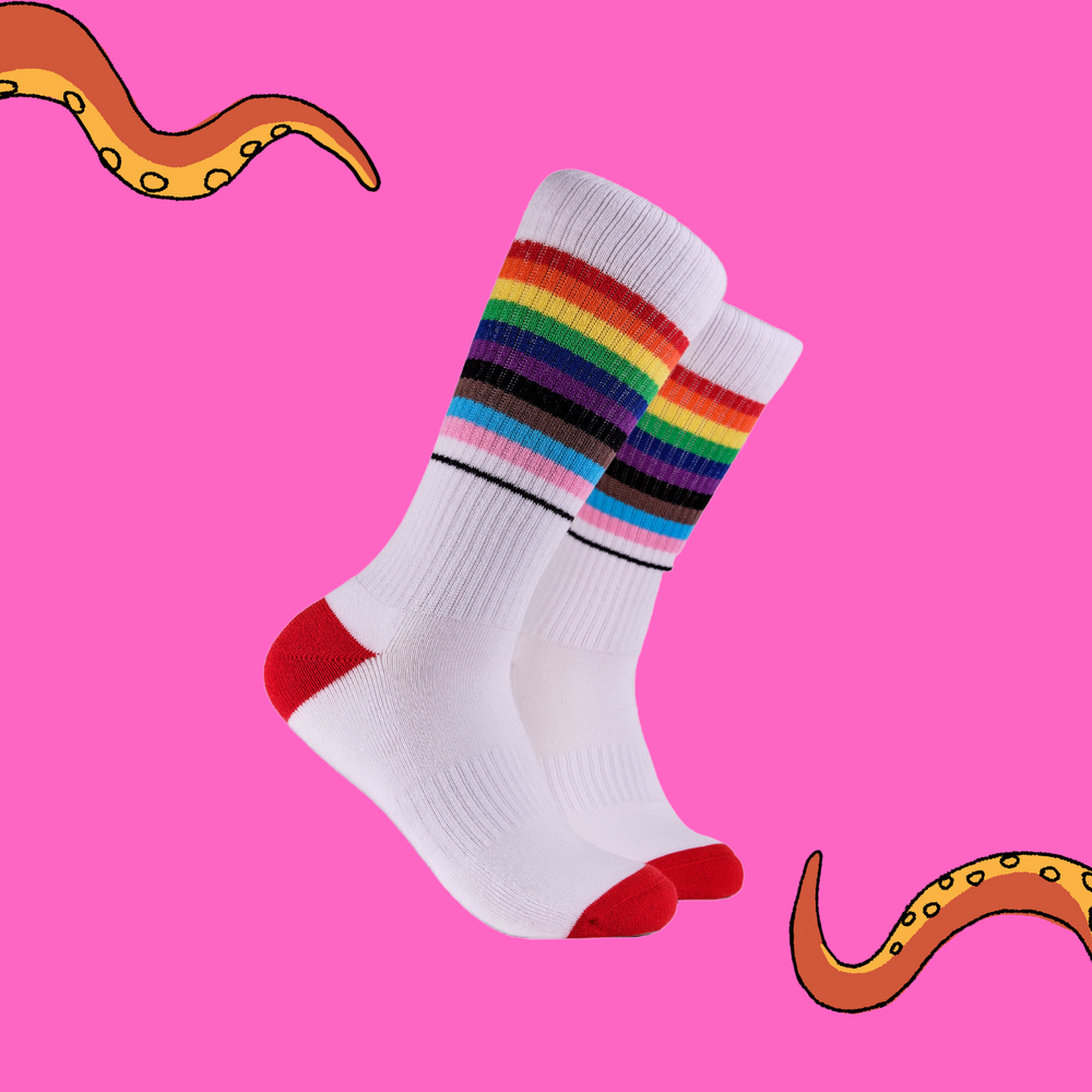 A pair of socks depicting the pride flag. White legs, white cuff, red heel and toe.