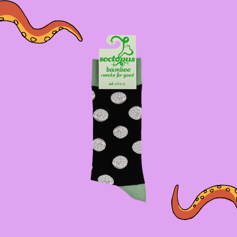 
                      
                        A pair of socks depicting golf balls. Black legs, light green cuff, heel and toe. In Soctopus Packaging.
                      
                    