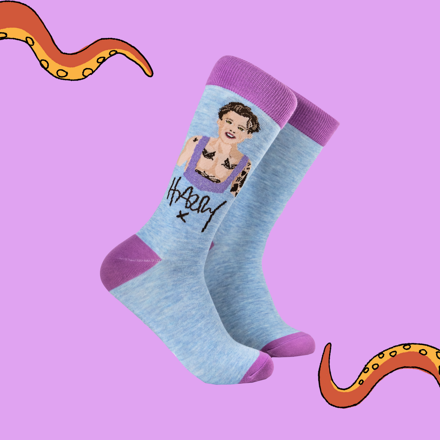 A pair of socks depicting Harry Styles. Blue legs, purple toe, heel and cuff. 