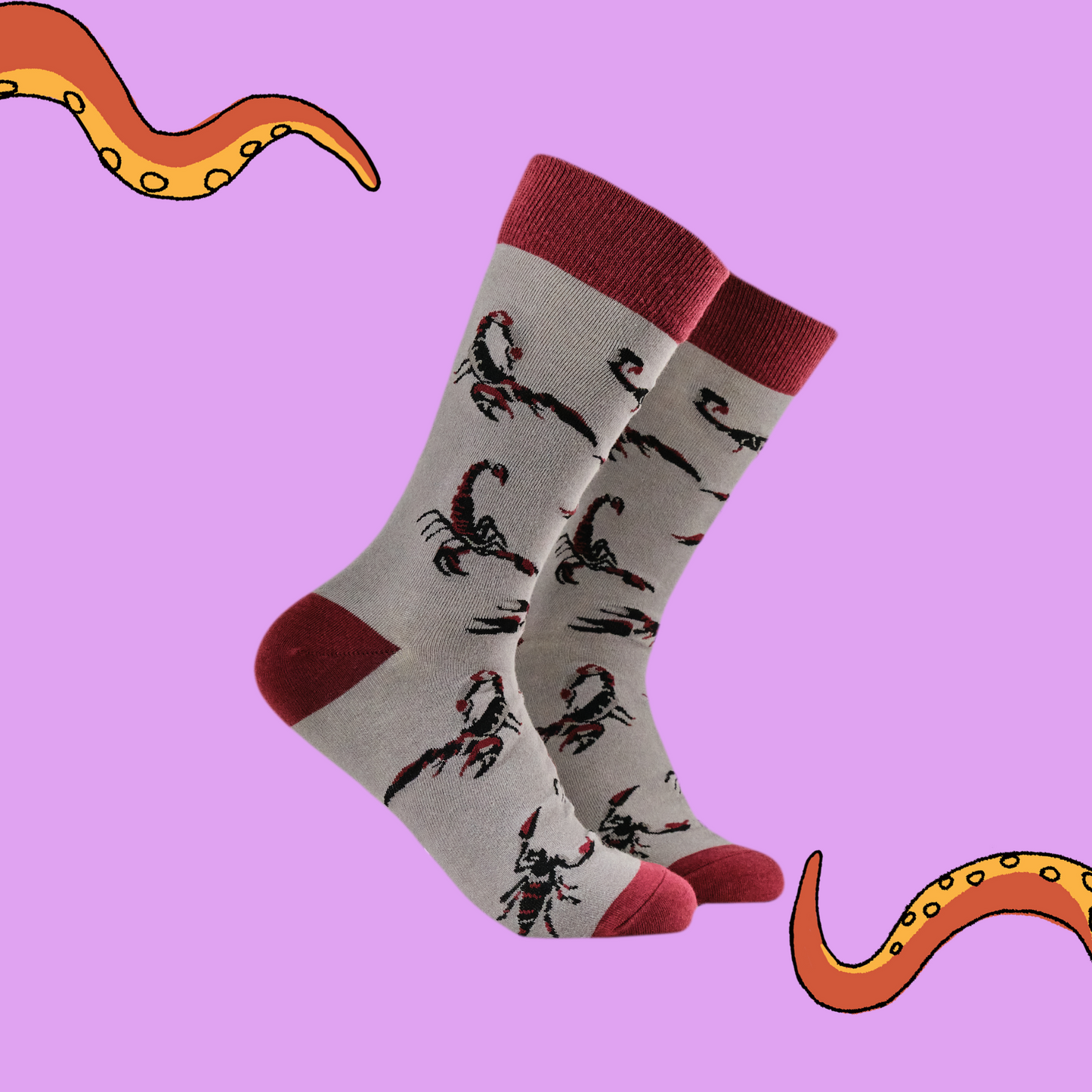 A pair of socks featuring a scorpion motif. Grey legs, red heel, toe and cuff. 