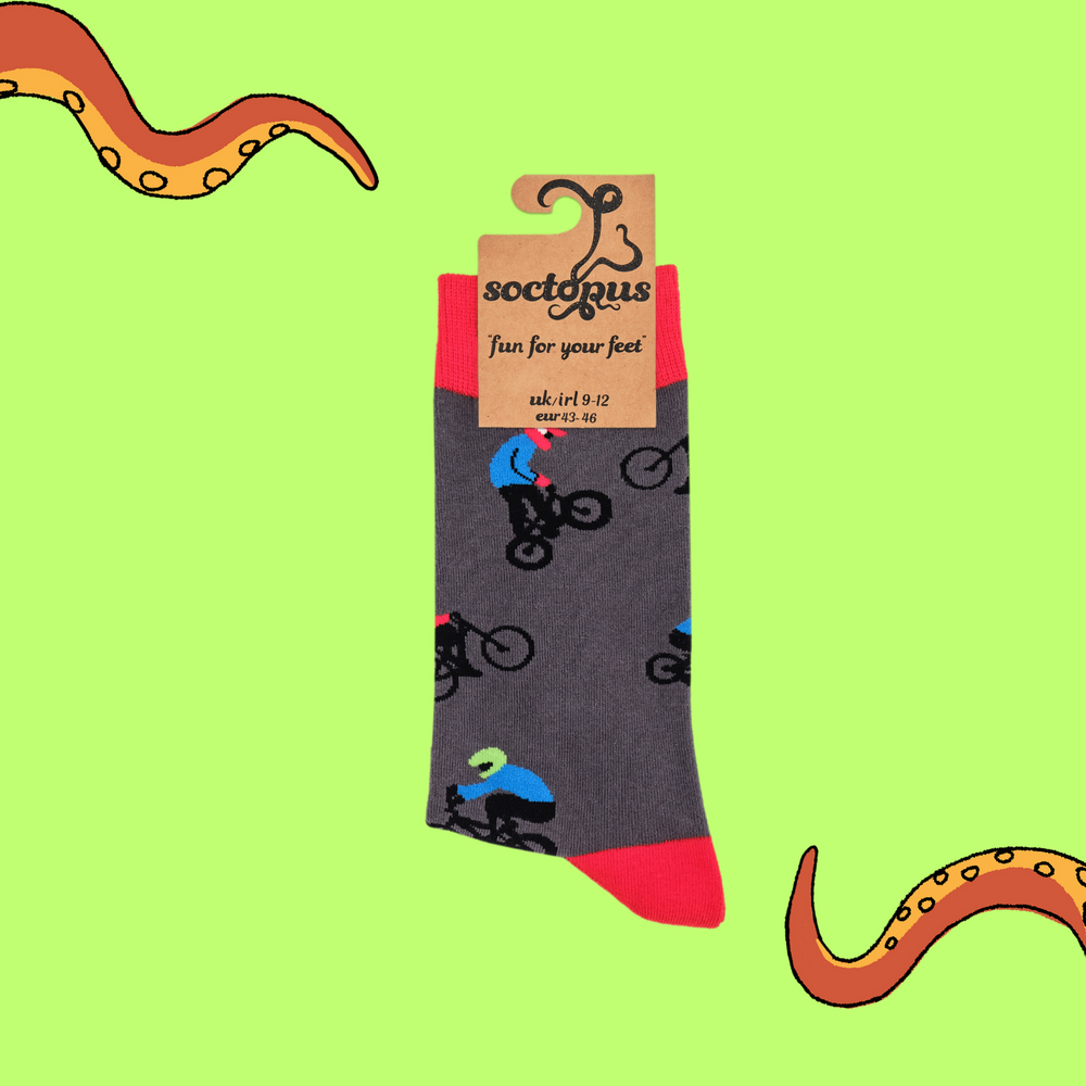 
                  
                    A pair of socks depicting people riding BMX bikes. Grey legs, red cuff, heel and toe. In Soctopus Packaging.
                  
                