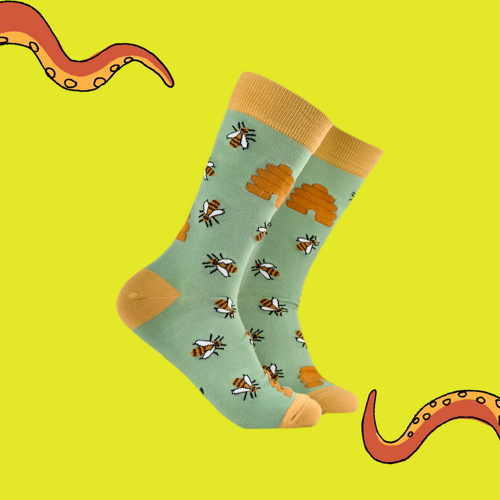 
                      
                        A pair of socks featuring honey bees. Green legs, yellow heel, toe and cuff. 
                      
                    