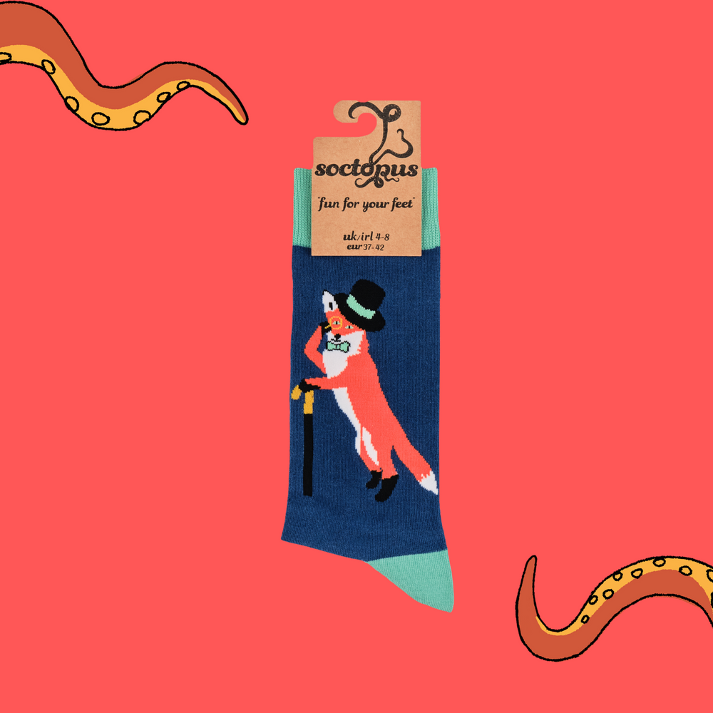 
                      
                        A pair of socks depicting a fox in a top hat and monocle. Blue legs, green cuff, heel and toe. In Soctopus Packaging.
                      
                    