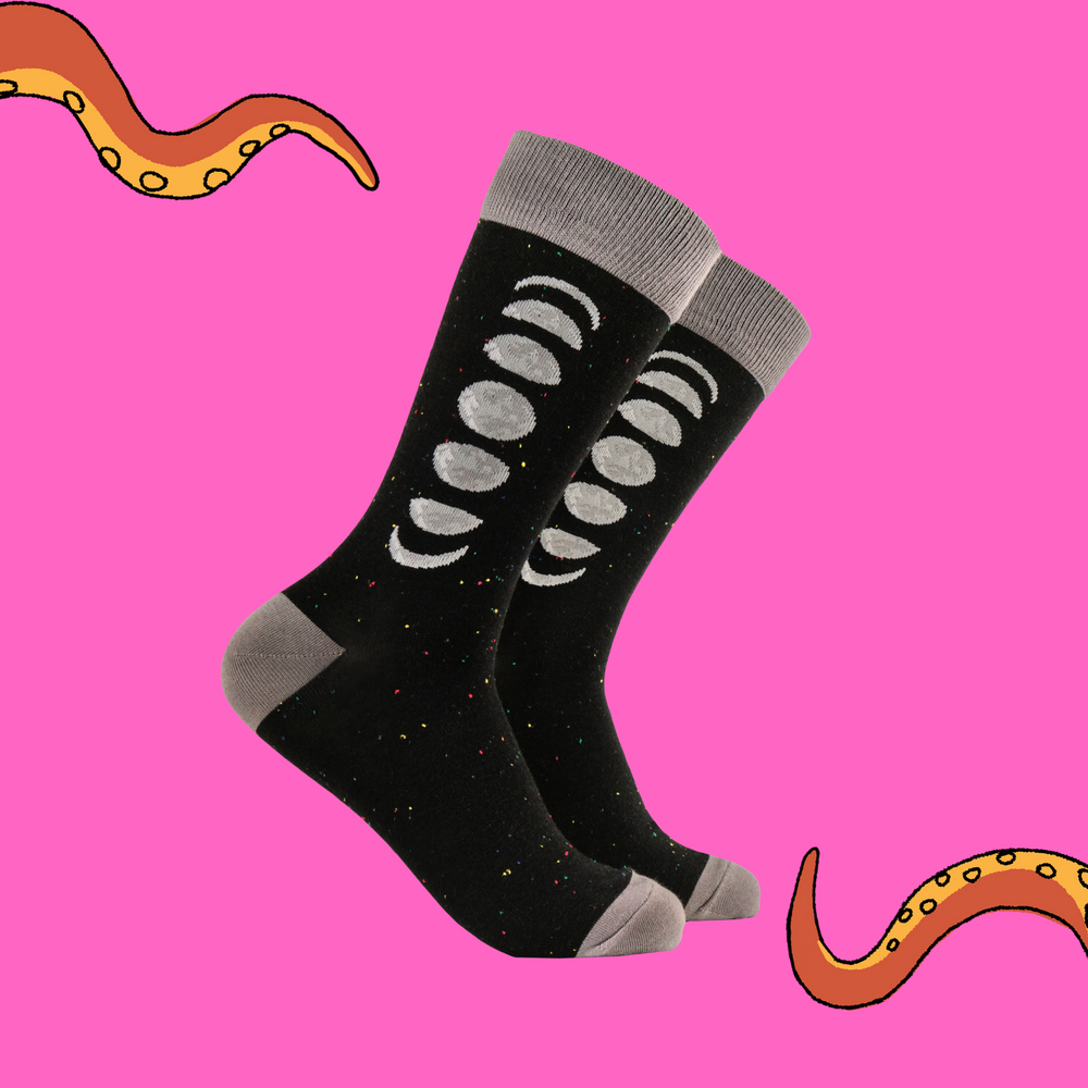 A pair of socks featuring the phases of the moon. Black legs, grey heel, toe and cuff. 