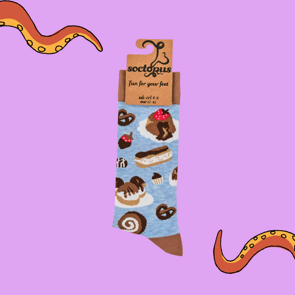 
                      
                        A pair of socks depicting cakes and chocolates. Blue legs, brown heel, toe and cuff. 
                      
                    