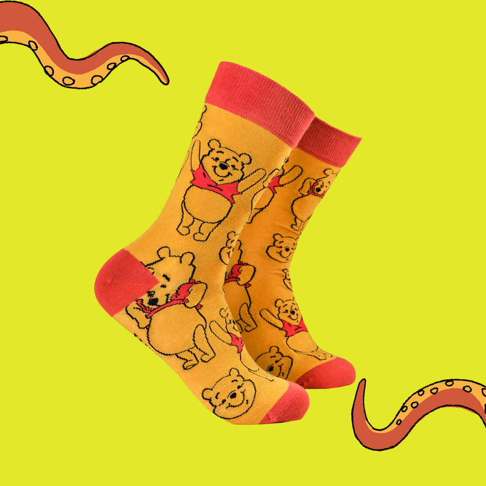 
                      
                        A pair of socks featuring Winne the Pooh. Yellow legs, red toe, cuff and heel. 
                      
                    