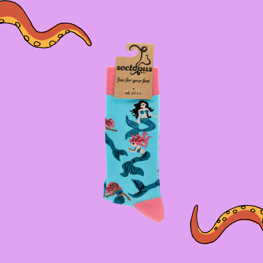 
                  
                    A pair of socks depicting mermaids swimming. Light blue legs, pink cuff, heel and toe. In Soctopus Packaging.
                  
                