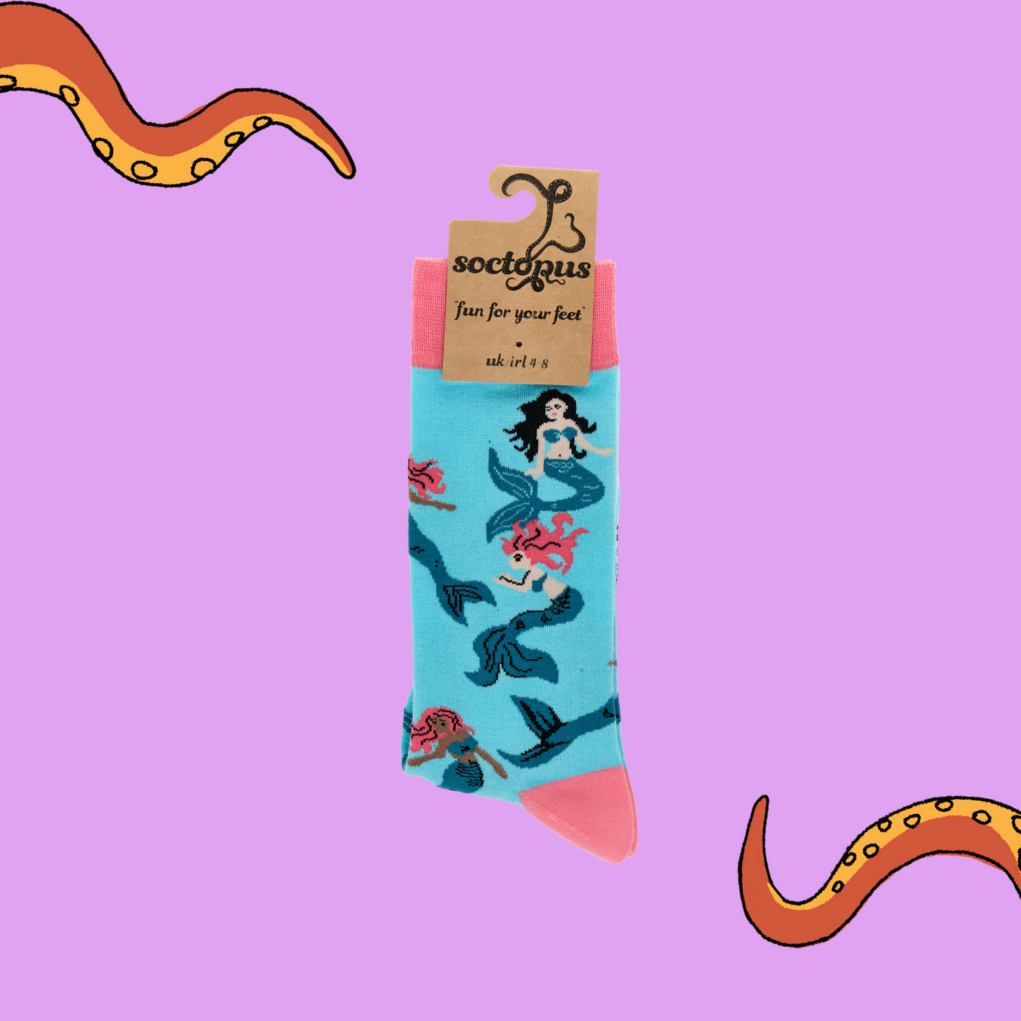 
                  
                    A pair of socks depicting mermaids swimming. Light blue legs, pink cuff, heel and toe. In Soctopus Packaging.
                  
                