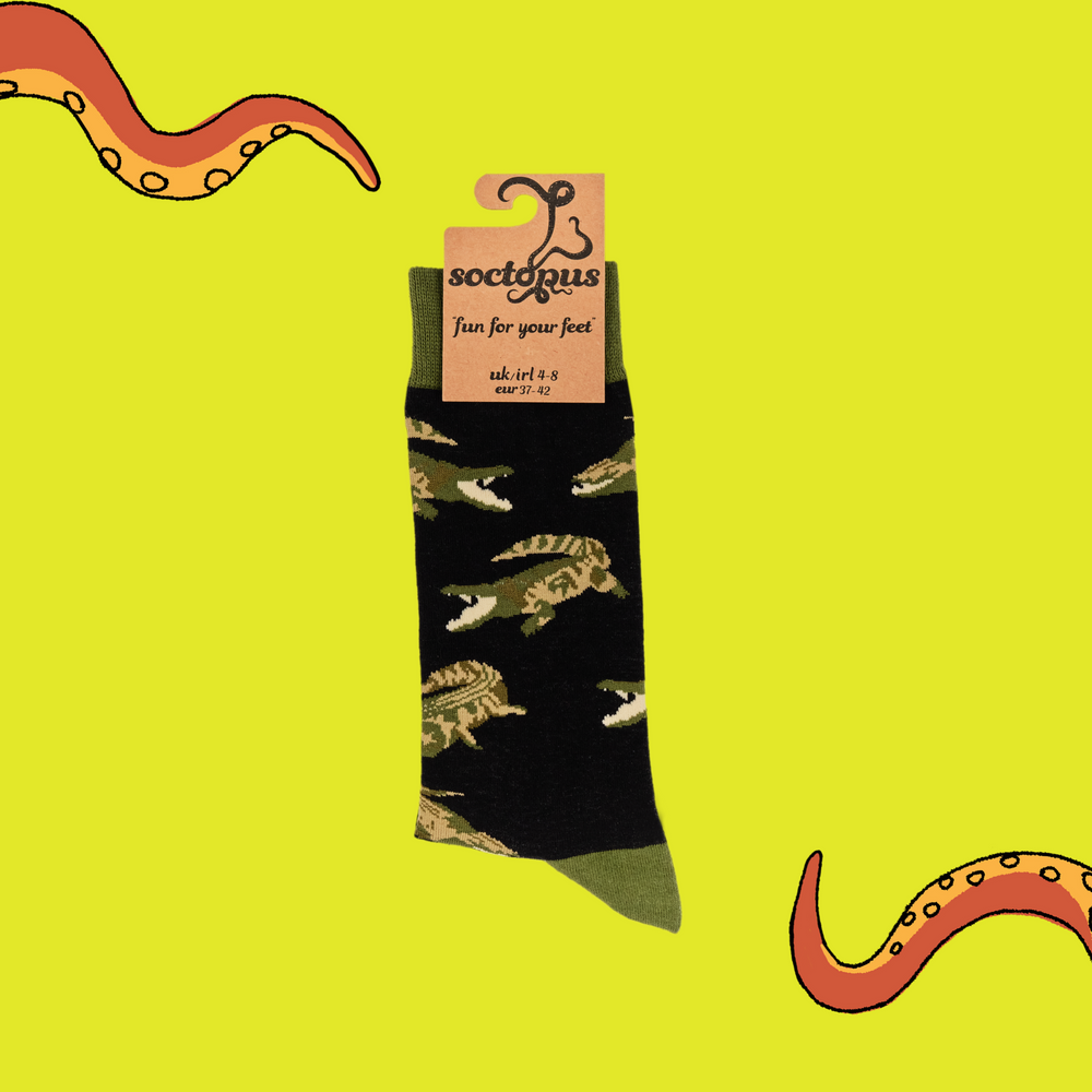 
                      
                        A pair of socks depicting crocodiles. Dark blue legs, green cuff, heel and toe. In Soctopus Packaging.
                      
                    