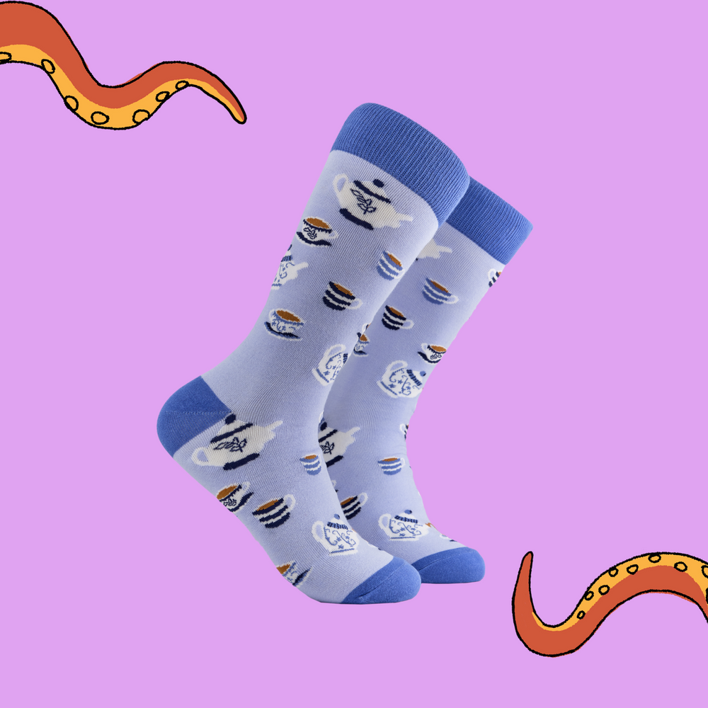 A pair of socks depicting tea cups and tea pots. Light blue legs, blue cuff, heel and toe.