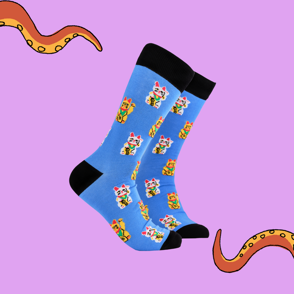 A pair of socks depicting lucky cats. Blue legs, black cuff, heel and toe.