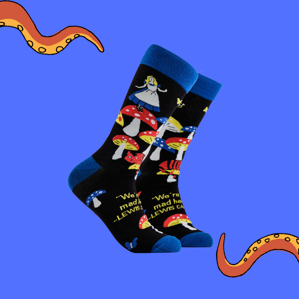 A pair of socks depicting Alice in wonderland and toadstools. Black legs, royal blue cuff, heel and toe.