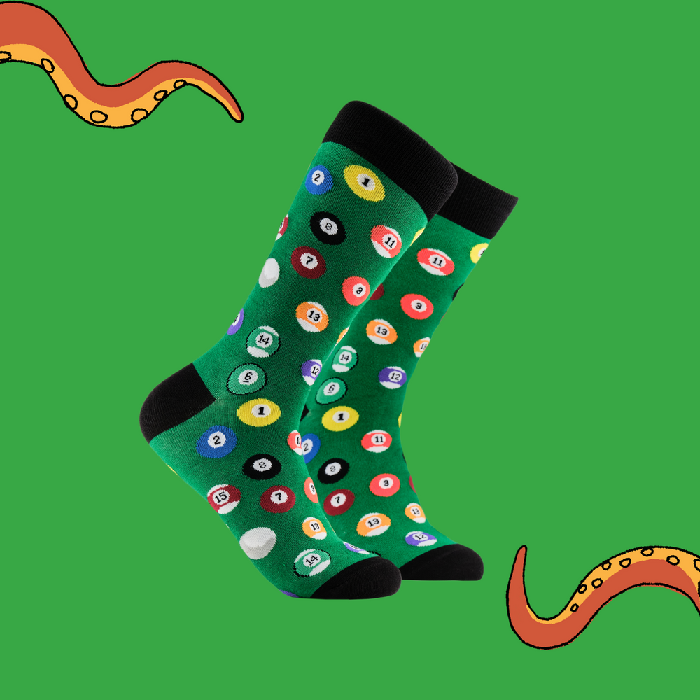 A pair of socks depicting pool balls. Green legs, black cuff, heel and toe.
