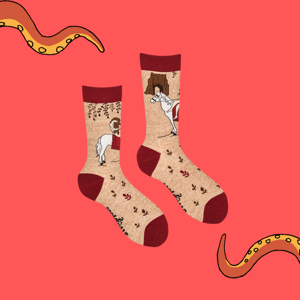 
                      
                        A pair of socks featuring Lady Godiva. Beige legs, red heel, toe and cuff. 
                      
                    