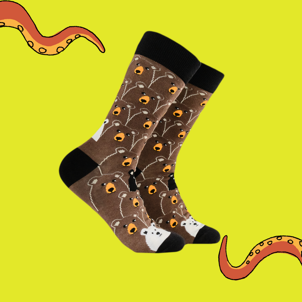 A pair of socks with a fun bear pattern. Brown legs, black heel, toe and cuff. 