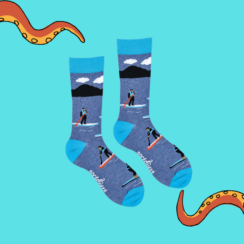 
                      
                        A pair of socks depicting paddle boarding. Blue legs, bright blue cuff, heel and toe.
                      
                    