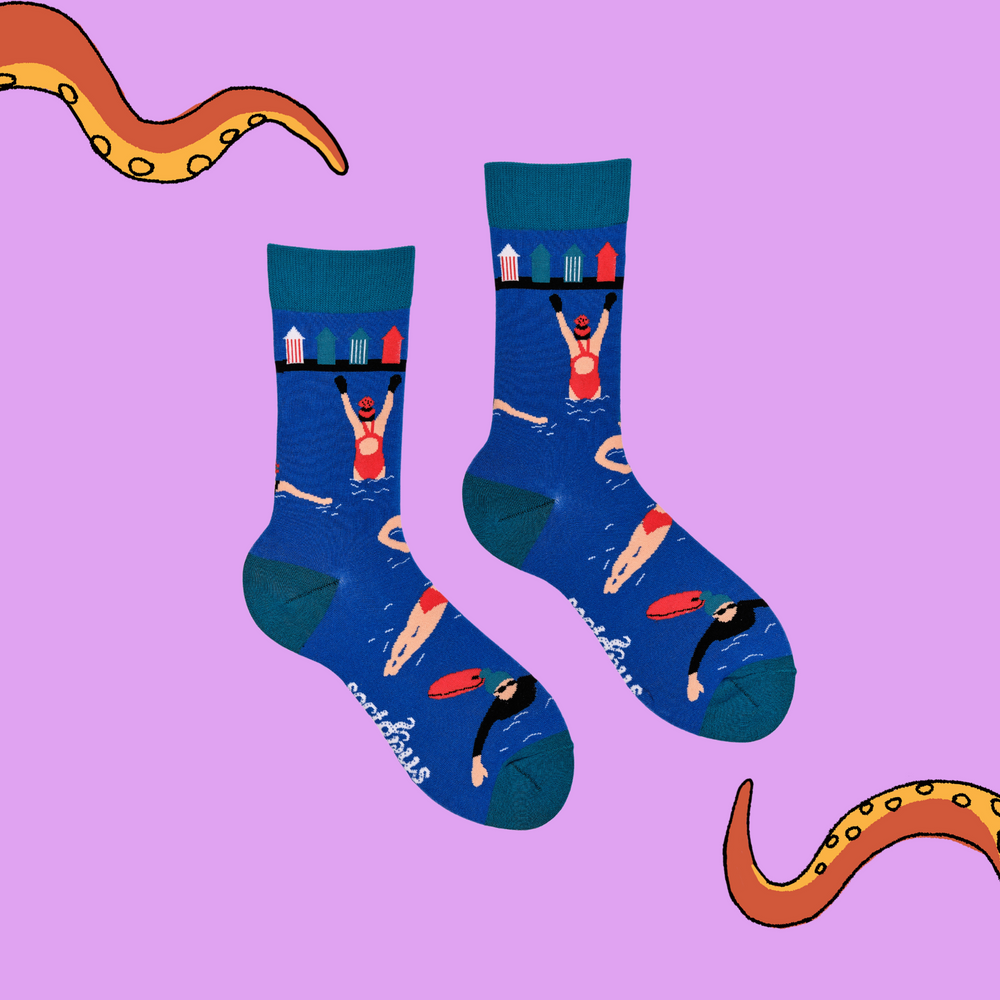 
                      
                        A pair of socks depicting swimmers and beach huts. Blue legs, light blue cuff, heel and toe.
                      
                    