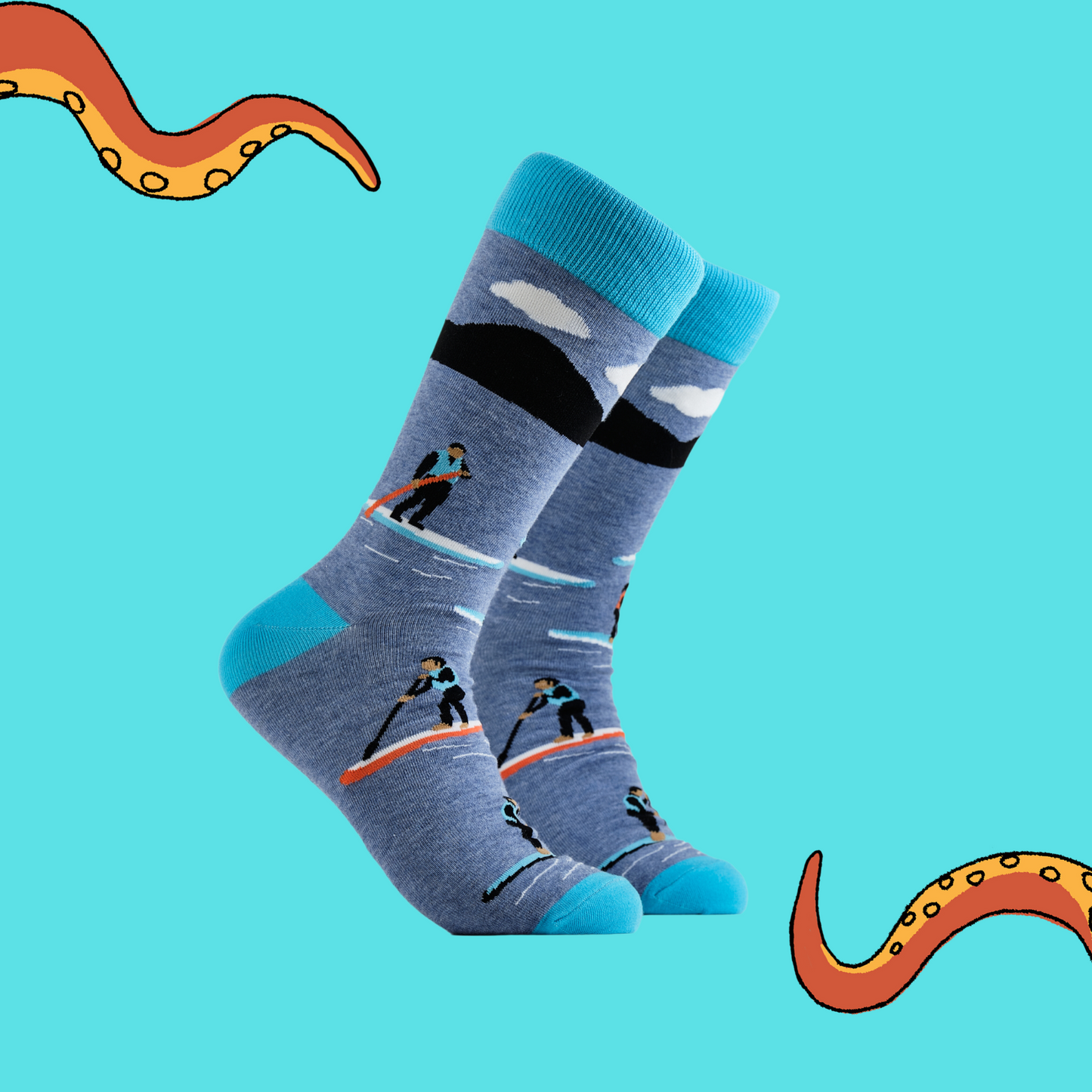 A pair of socks depicting paddle boarding. Blue legs, bright blue cuff, heel and toe.