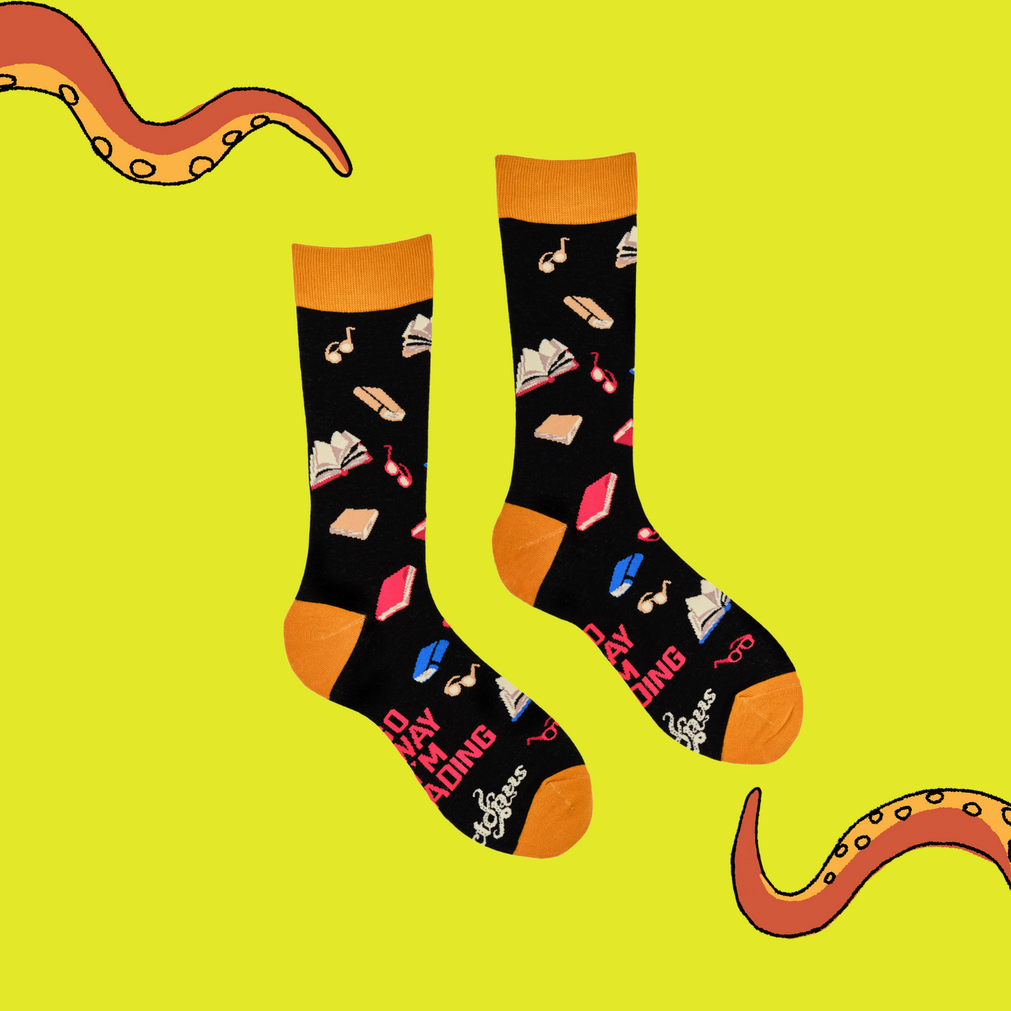 
                  
                    A pair of socks depicting books and reading glasses. Black legs, yellow cuff, heel and toe.
                  
                
