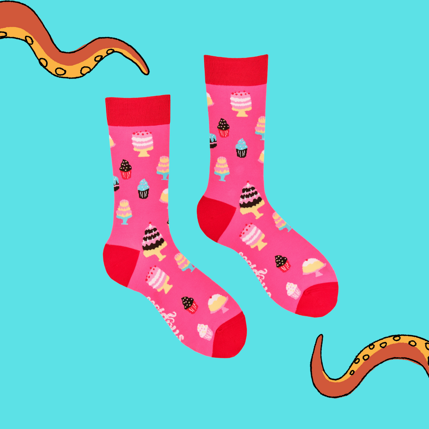 A pair of socks depicting cakes. Pink legs, red cuff, heel and toe.