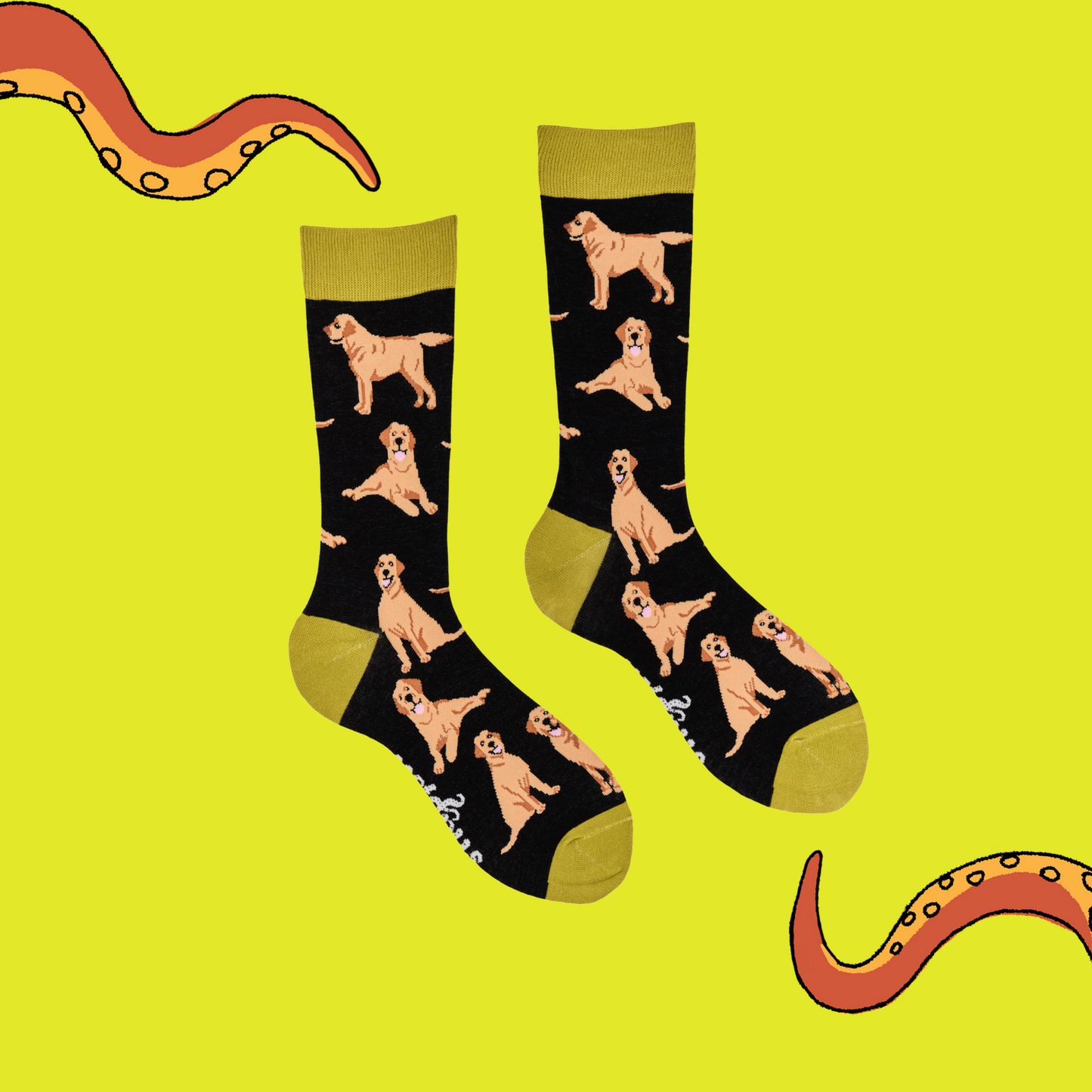 
                  
                    A pair of socks depicting Labrador dogs. Black legs, mustard cuff, heel and toe.
                  
                