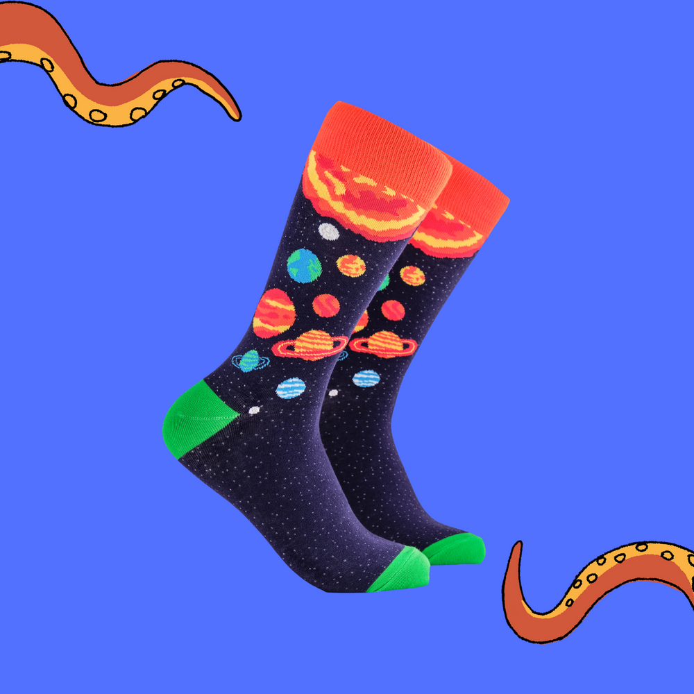 A pair of socks depicting planets and stars. Purple legs, orange cuff, green heel and toe.