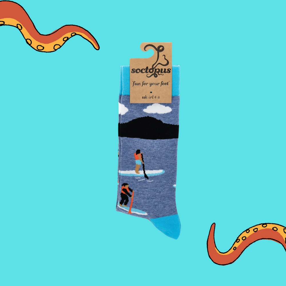 
                      
                        A pair of socks depicting paddle boarding. Blue legs, bright blue cuff, heel and toe. In Soctopus Packaging.
                      
                    