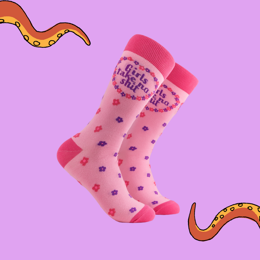 A pair of socks depicting the words "Girls Tale No Shit". Pink legs, dark pink cuff, heel and toe
