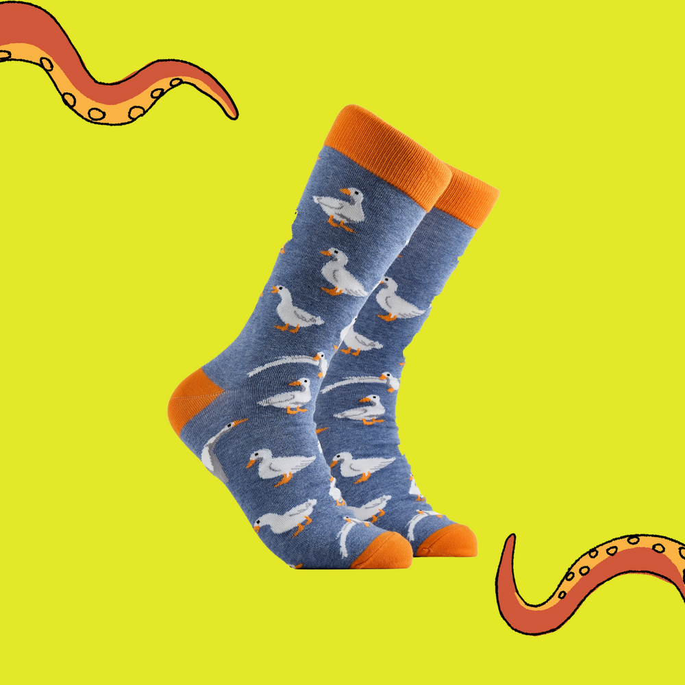  A pair of socks depicting white ducks. Blue legs, orange cuff, heel and toe.