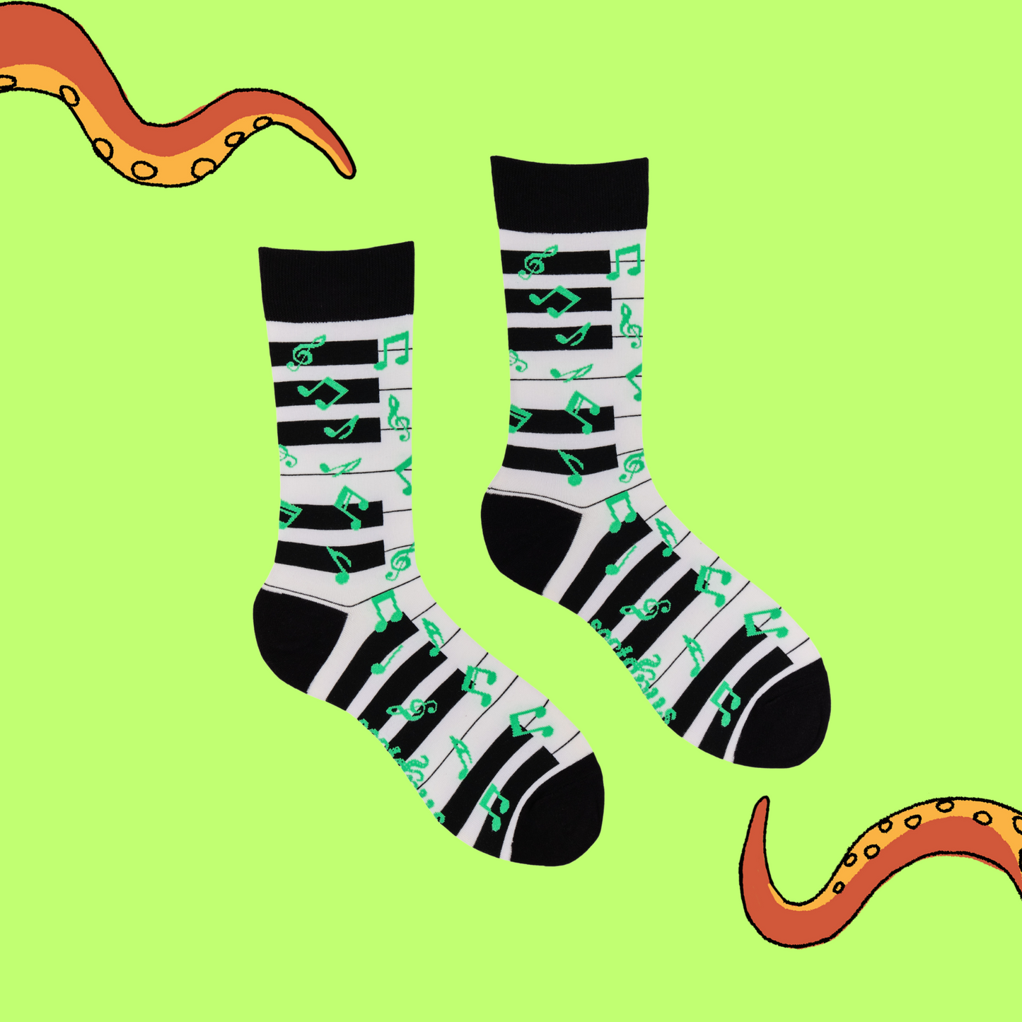 
                  
                    A pair of socks depicting a piano keyboard and green music notes. Black and white piano legs, black cuff, heel and toe.
                  
                