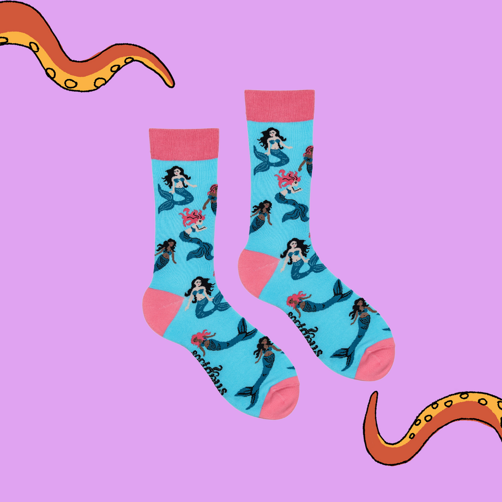 
                  
                    A pair of socks depicting mermaids swimming. Light blue legs, pink cuff, heel and toe.
                  
                