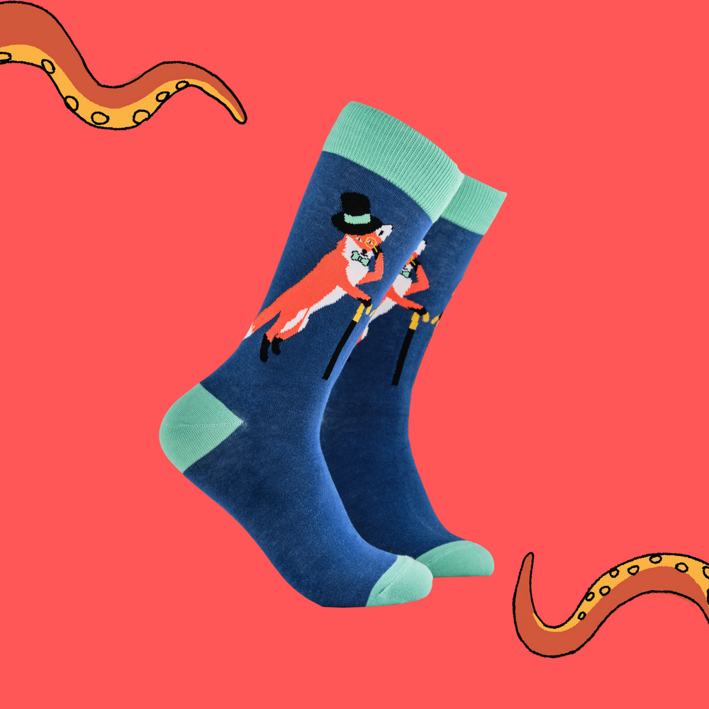 
                      
                        A pair of socks depicting a fox in a top hat and monocle. Blue legs, green cuff, heel and toe.
                      
                    