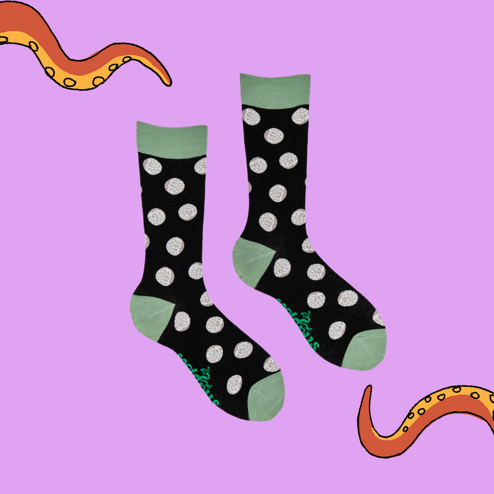 
                      
                        A pair of socks depicting golf balls. Black legs, light green cuff, heel and toe.
                      
                    