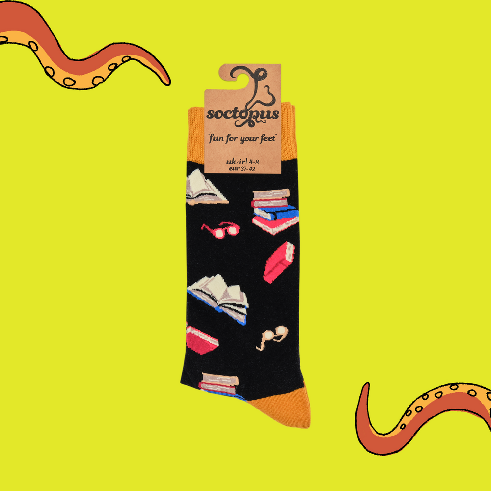 
                      
                        A pair of socks depicting books and reading glasses. Black legs, yellow cuff, heel and toe. In Soctopus Packaging.
                      
                    