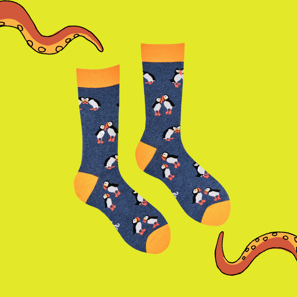 
                      
                        A pair of socks depicting tea cups and tea pots. Blue legs, yellow cuff, heel and toe.
                      
                    