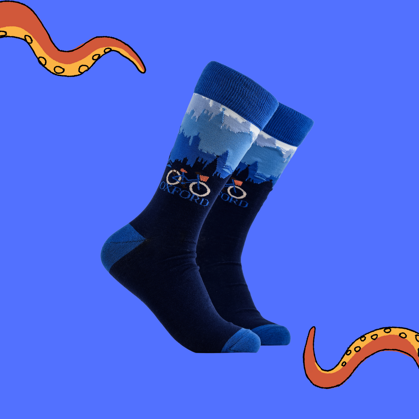 
                  
                    A pair of socks depicting the Oxford skyline and a traditional bicycle. Blue legs, blue cuff, heel and toe.
                  
                