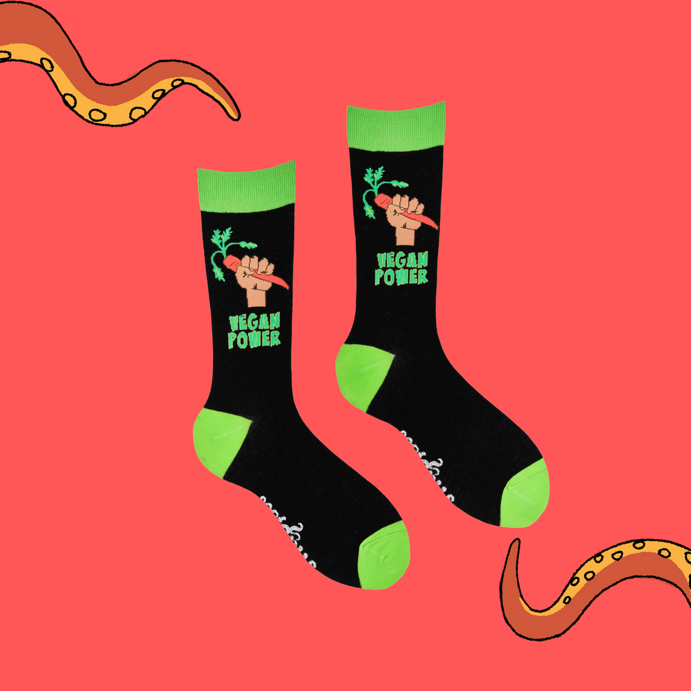 
                  
                    A pair of socks depicting a fist holding a carrot and the phrase 'Vegan Power'. Black legs, bright green cuff, heel and toe.
                  
                
