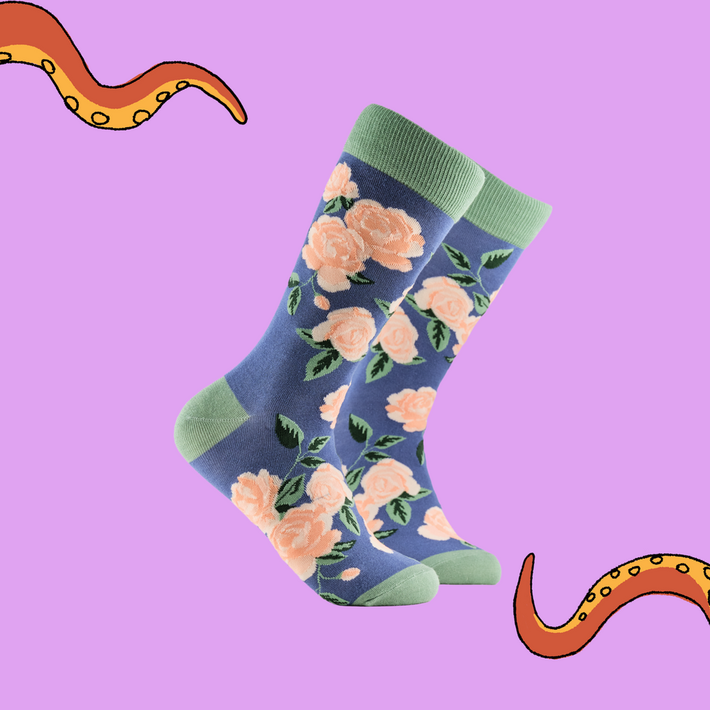 
                      
                        Rose Floral Bamboo Socks. A pair of socks depicting pink roses. Blue legs, green cuff, heel and toe.
                      
                    