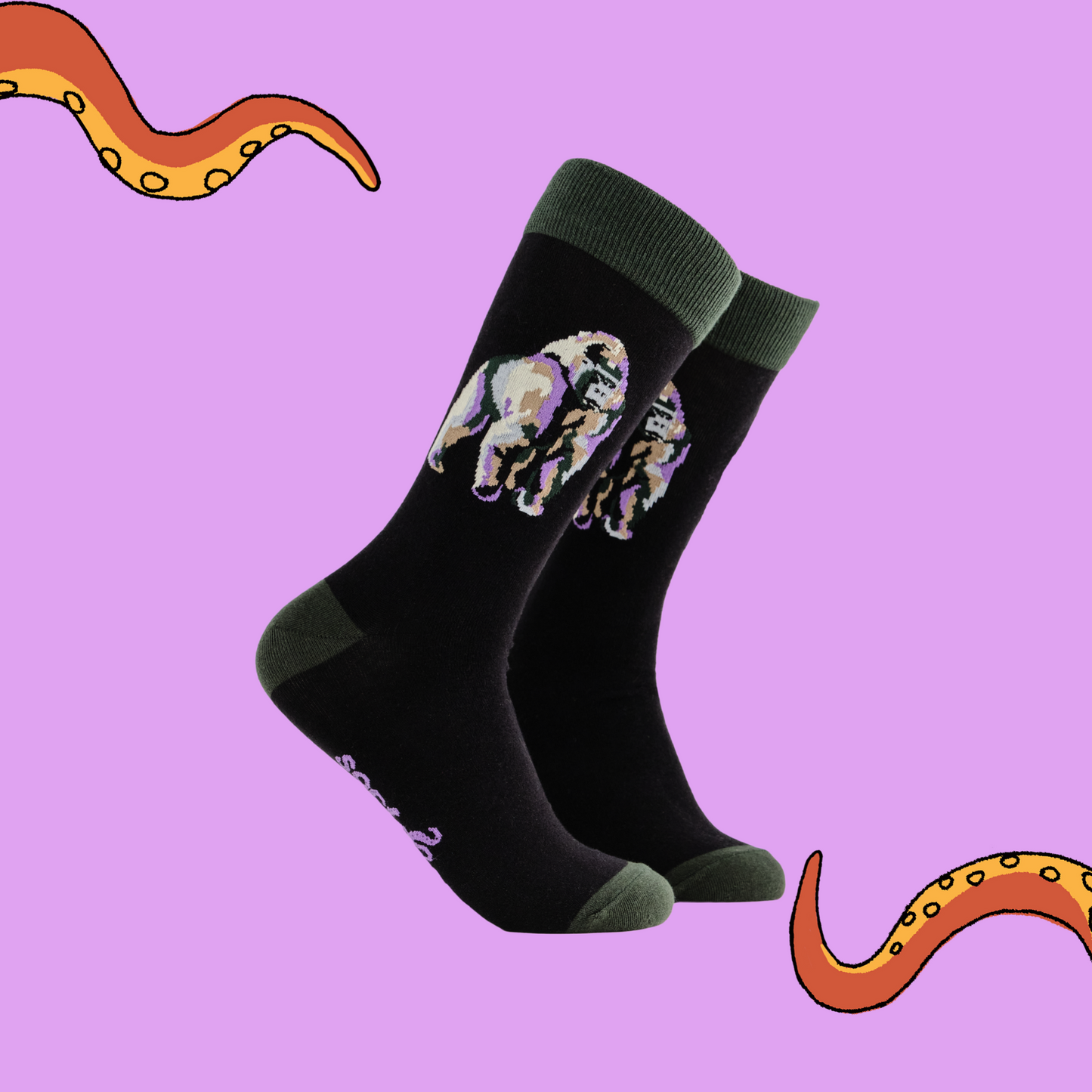 A pair of socks depicting a silverback gorilla. Black legs, green cuff, heel and toe.