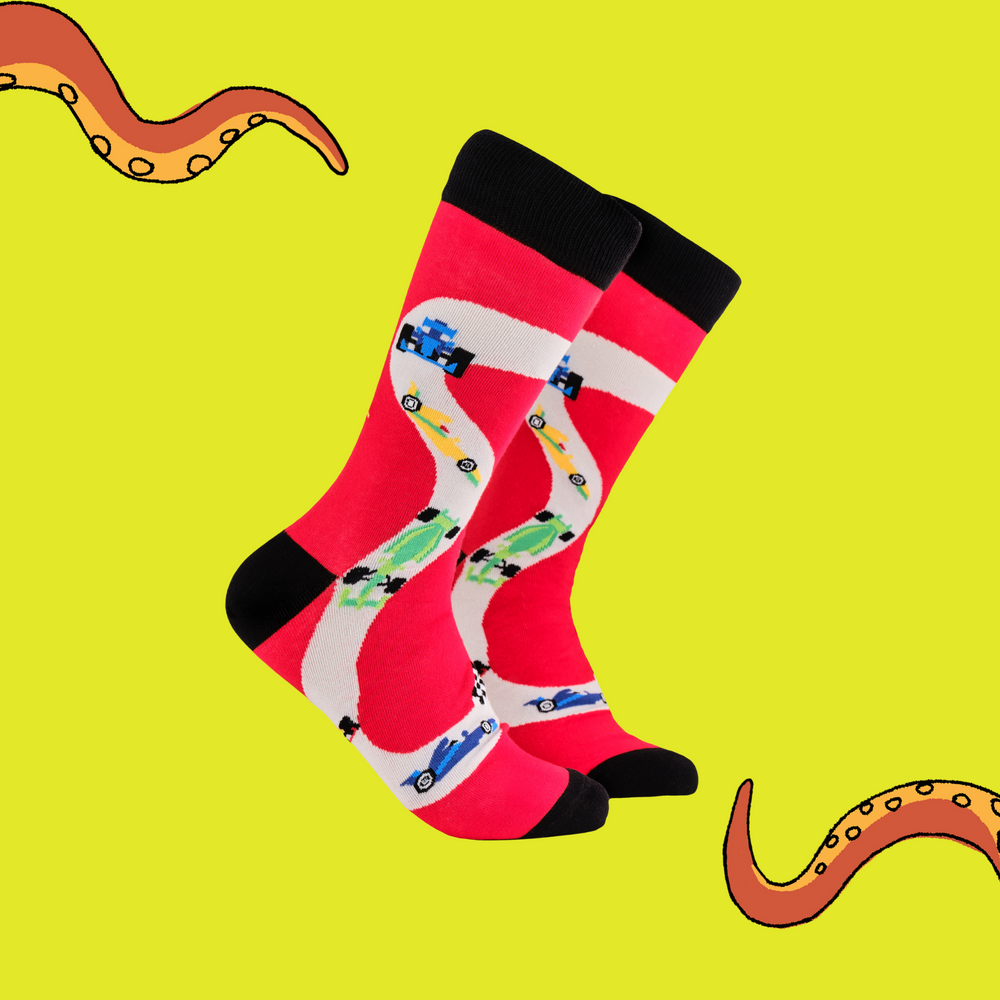 A pair of socks depicting F1 cars. Red legs, black cuff, heel and toe.