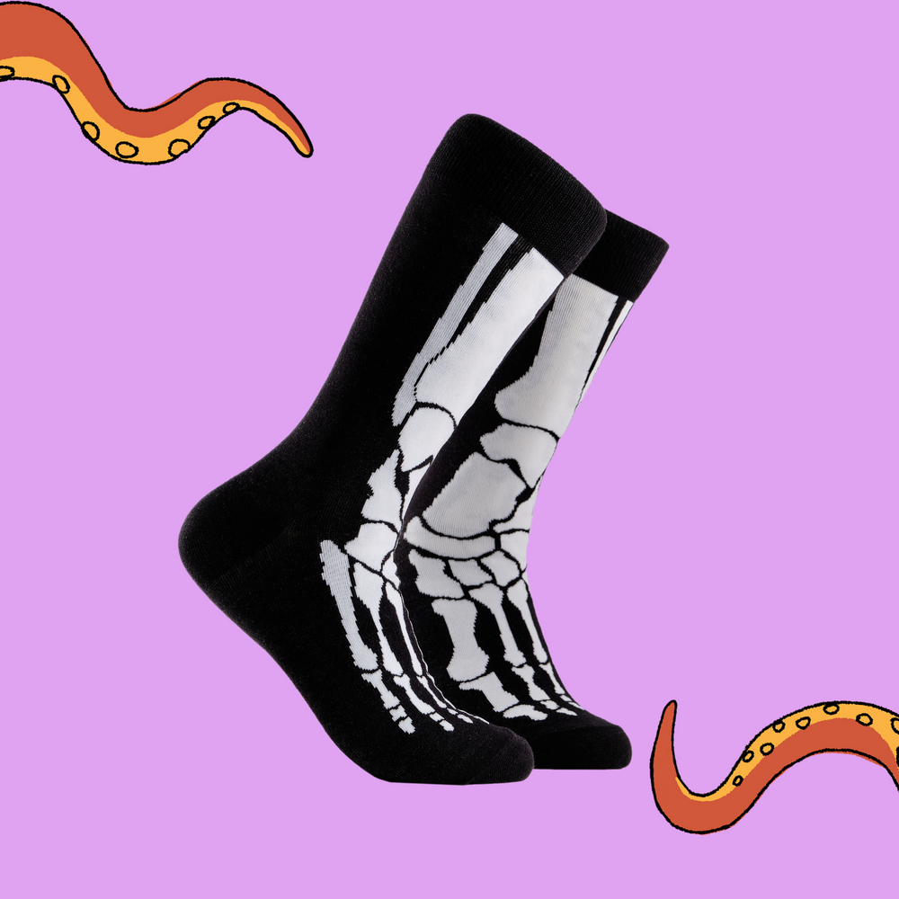 A pair of socks depicting skeleton feet. Black and White legs, black cuff, heel and toe.