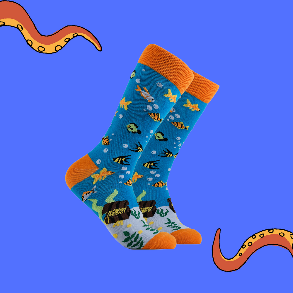 A pair of socks depicting fish under the sea and some long lost treasure. Blue legs, orange cuff, heel and toe.