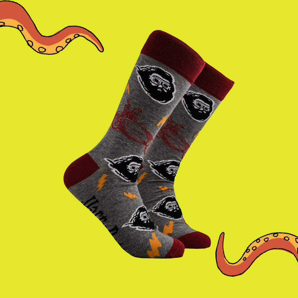 A pair of socks depicting Hagrid wearing his flying goggles. Grey legs, red toe, heel and cuff.